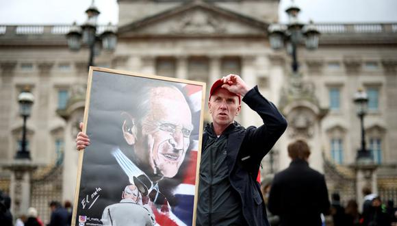 Un hombre sostiene un cartel que representa al difunto príncipe Felipe, esposo de la reina Isabel, quien murió a la edad de 99 años, en las afueras del Palacio de Buckingham en Londres, Gran Bretaña, el 10 de abril de 2021. (REUTERS/Henry Nicholls).