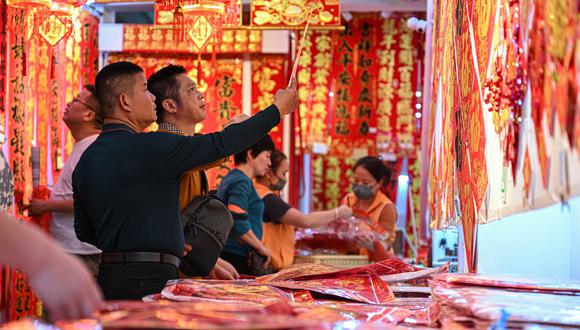 El rojo es un color que predomina en las celebraciones por el Año Nuevo Chino. Se cree que atrae la felicidad y la buena fortuna.  En la imagen, la gente compra coplas del Festival de la Primavera en la provincia Hainan, en China, días antes del inicio del Año Nuevo Chino 2024. (Foto: Xinhua/Pu Xiaoxu)