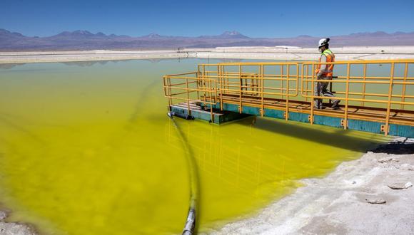 A mine supervisor inspects an evaporation pond of lithium-rich brine in the Atacama Desert in Salar de Atacama, Chile. Photographer: John Moore/Getty Images