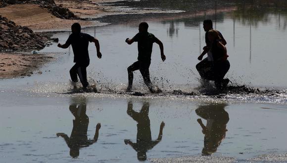Migrantes venezolanos corren mientras cruzan el Río Bravo, de México hacia los Estados Unidos (Foto: AFP)