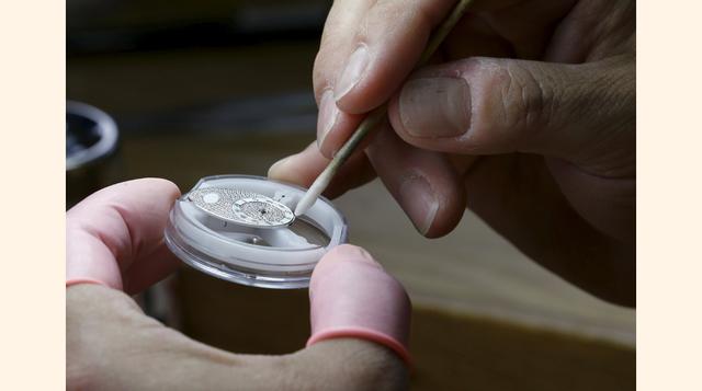 Un trabajador limpia las lujosas piezas que componen un reloj Zenith. (Foto: Reuters)