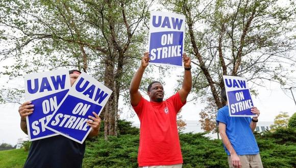 Miembros del sindicato UAW se manifiestan con carteles de huelga tras salir de una planta de distribución de componentes de automóviles de General Motors. (Foto: AFP/Archivos)