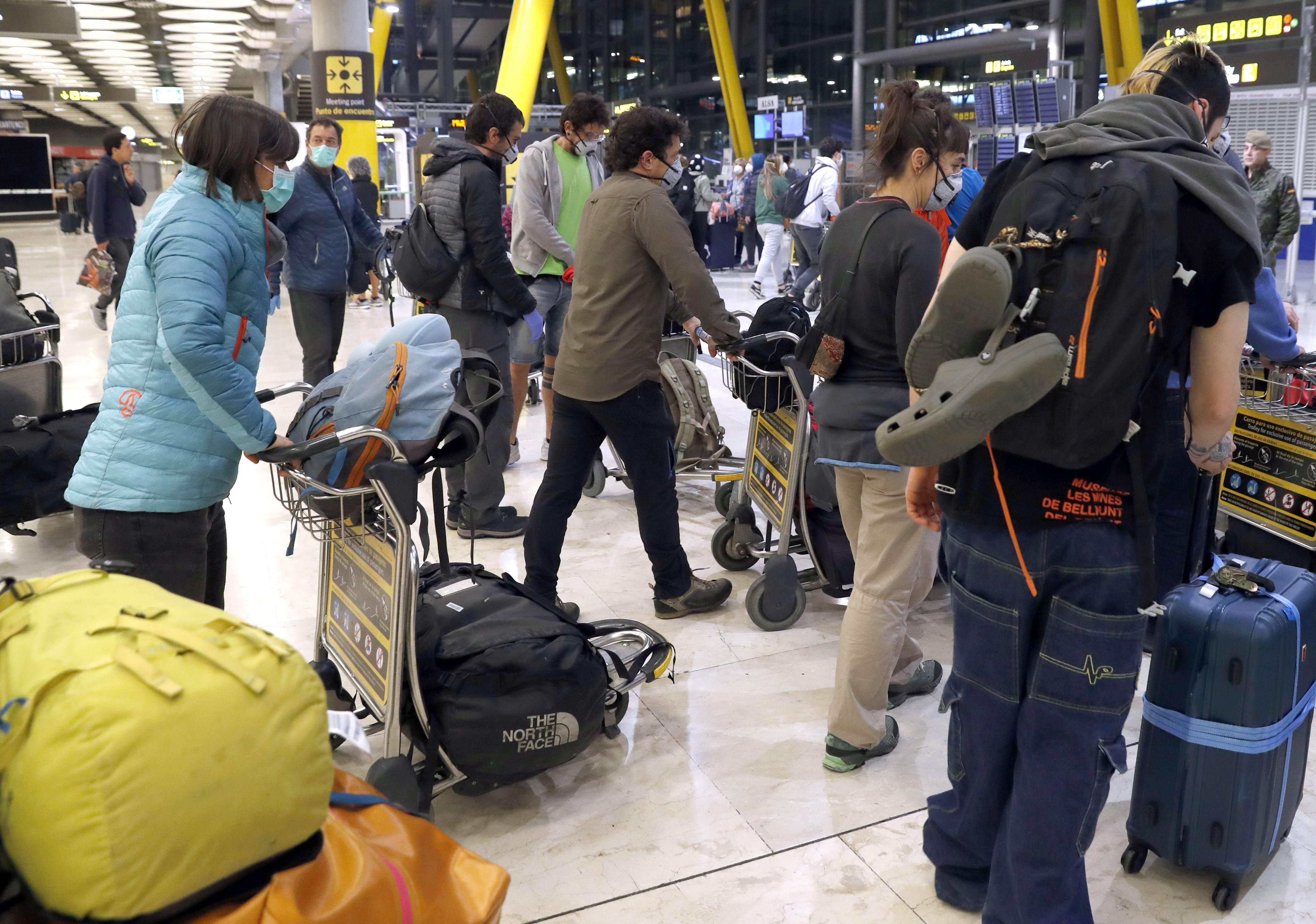 Varios pasajeros a su llegada al aeropuerto Madrid Barajas-Adolfo Suarez durante la segunda semana de aislamiento para frenar el coronavirus.  (Foto: EFE)