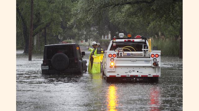 Un trabajador trata de rescatar con una grúa un vehículo atrapado en una calle inundada en Georgetown, Carolina del Sur. La mayoría de las carreteras principales de Carolina del Sur han sido cerradas debido a las inundaciones. Vastas extensiones de los Es