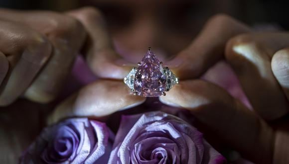 Un empleado de Christie's muestra un elegante diamante de talla brillante de pera modificado de color rosa vivo llamado 'The Fortune Pink' de 18,18 quilates, durante una vista previa en Christie's en Ginebra, Suiza, el 2 de noviembre de 2022. (Foto: EFE/EPA/MARTIAL TREZZINI)