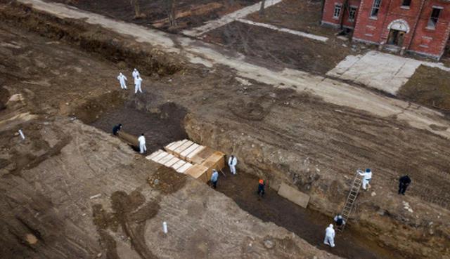 Para el entierro en la isla, los muertos se envuelven en bolsas para cadáveres y se colocan dentro de ataúdes de pino. (REUTERS/Lucas Jackson).