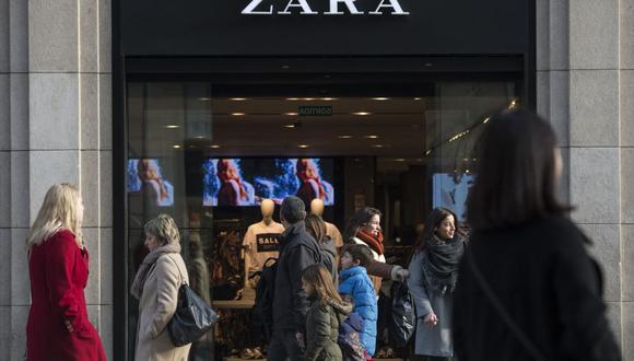 En esta foto de archivo tomada el 7 de enero de 2017, la gente pasa por una tienda de Zara anunciando descuentos en el primer día de las rebajas de invierno en Barcelona. (Foto de Josep LAGO / AFP)