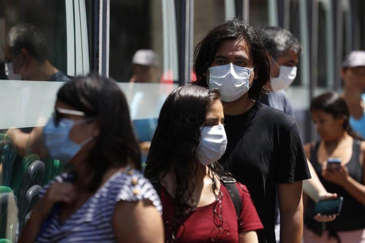 Personas con mascarillas en las calles de Lima. (Foto: EFE)