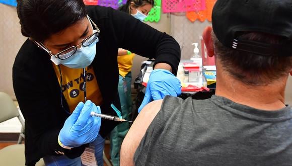 La enfermera registrada Mariam Salaam administra la inyección de refuerzo de Pfizer en un sitio de vacunación y prueba de Covid, en Los Ángeles el 5 de mayo de 2022. (Foto de Frederic J. BROWN / AFP)