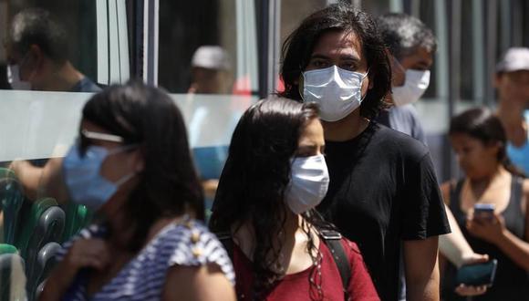 Personas con mascarillas en las calles de Lima. (Foto: EFE)