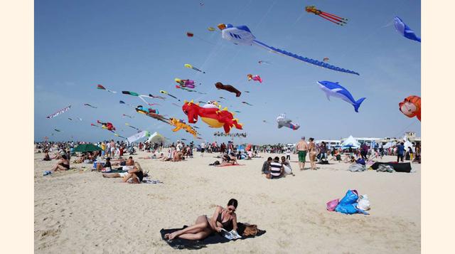 Dubai, Emiratos Árabes Unidos; Una mujer disfruta del sol mientras cientos de cometas surcan el cielo en la playa de Jumeirah durante un festival internacional, el 19 de marzo.(foto:Kamran Jebreili/AP Images)