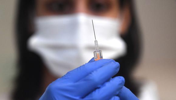 Una mujer sostiene un vial con la etiqueta "Coronavirus COVID-19 Vacuna" en inglés y una jeringa médica en esta imagen de ilustración tomada el 30 de octubre de 2020. (Foto referencial: EFE)
