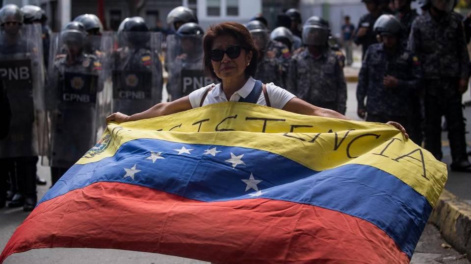 Una mujer ondea una bandera venezolana durante una marcha estudiantil en Caracas (Venezuela). Miguel Gutiérrez EFE