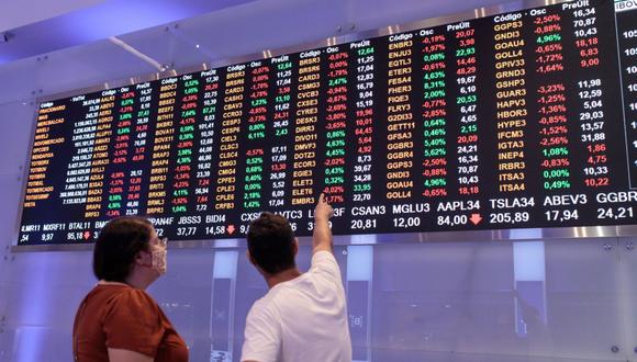 A visitor points to an electronic board displaying stock activity at the Brasil Bolsa Balcao (B3) stock exchange in Sao Paulo, Brazil, on Monday, Nov. 8, 2021. The Ibovespa opened 0.2 percent lower at 104,627.30 in Sao Paulo, with Brasil Bolsa Balcao contributing the most to the index decline, decreasing 1.9 percent. Photographer: Patricia Monteiro/Bloomberg