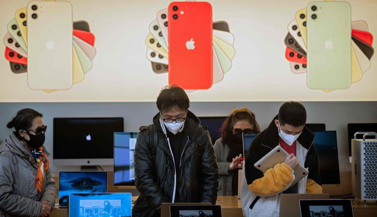 Los usuarios continuarán teniendo apoyo y soporte para sus dispositivos en internet. Clientes que usan mascarillas como medida preventiva contra el coronavirus se ven dentro de una tienda de Apple en Beijing. (AFP).