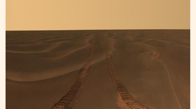 Foto del horizonte tomada por el Opportunity cuando pasó un mes atascado en una pronunciada ondulación en la arena a la que la NASA puso el nombre de ´Purgatorio´. En la imagen se puede apreciar el rastro de las ruedas sobre la superficie de Marte (NASA/J