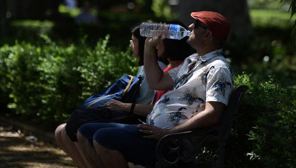 Un hombre bebe agua sentado a la sombra para refrescarse de las altas temperaturas en Sevilla el 26 de abril de 2023, mientras España se prepara para una ola de calor temprana. (Foto por CRISTINA QUICLER / AFP)