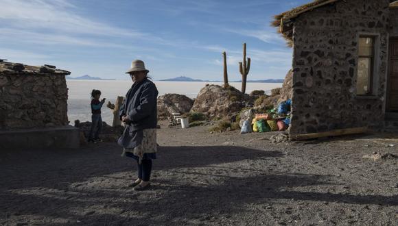 Una persona se encuentra cerca de casas en la Isla Incahuasi en el Salar de Uyuni en Potosí, Bolivia, el martes 10 de diciembre de 2019. América del Sur controla alrededor del 70% de las reservas mundiales de litio, el metal utilizado en baterías recargables, baterías para teléfonos móviles y vehículos eléctricos, y se considera que las futuras instalaciones de refinación y ensamblaje de baterías ayudarán a impulsar las economías. Fotógrafo: Carlos Becerra/Bloomberg