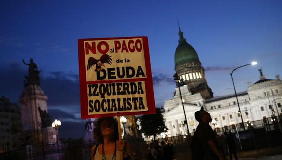 Una manifestante sostiene un cartel durante una protesta contra el acuerdo del Fondo Monetario Internacional (FMI) mientras los legisladores votan sobre el proyecto de ley frente al edificio del Congreso Nacional en Buenos Aires, Argentina, el jueves 17 de marzo de 2022.
