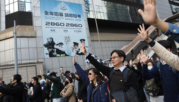 Los manifestantes en favor de la democracia de Hong Kong levantan la mano simbolizando las 'cinco demandas' mientras participan en una manifestación organizada por el Frente Civil de Derechos Humanos en el 2019. (Foto: EFE).