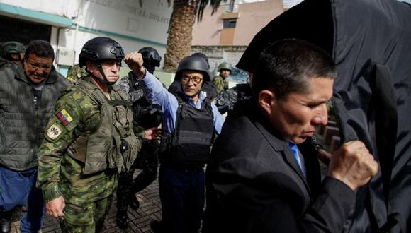 Rodeado por un grupo de policías y protegido con barreras antibalas, así llegó a sufragar Christian Zurita, candidato de Construye que reemplazó al asesinado Fernando Villavicencio. (Foto: AFP)