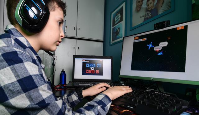 A los nueve años, el confinamiento por coronavirus junto a los padres puede ser tedioso. Así que Lupo, un niño de Milán en Italia, decidió crear su propio videjuego para jugar en línea con sus amigos. (Miguel MEDINA / AFP).