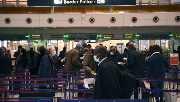 Los viajeros hacen cola en el mostrador de inmigración del aeropuerto internacional Roissy Charles-de-Gaulle, a medida que entran en vigencia las nuevas restricciones fronterizas de Covid-19. (Foto de Christophe ARCHAMBAULT / AFP)