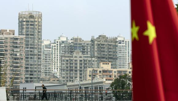 Una bandera china frente a edificios residenciales en Shanghái, China, el lunes 17 de octubre de 2022. Photographer: Qilai Shen/Bloomberg