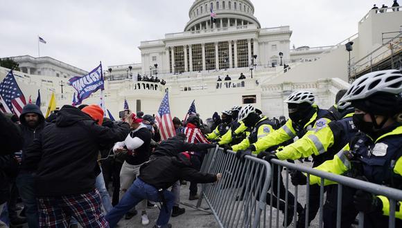 En esta fotografía de archivo del miércoles 6 de enero de 2021, partidarios de Donald Trump intentan atravesar una barrera policial en el Capitolio de Washington (Estados Unidos). (AP/Julio Cortez)