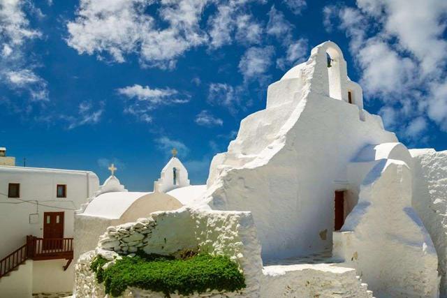 FOTO 11 | 11. La iglesia de Panagia Paraportiani. Está situada en el barrio de Kastro, en la ciudad de Chora, Mikonos. Su nombre significa Nuestra Señora de la Puerta Lateral, ya que su entrada se encontró en la puerta lateral de la entrada del área de Kastro. La construcción de la iglesia comenzó en 1425 y no se terminó hasta el siglo XVII.