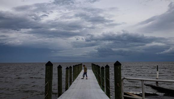 Un reportero camina hacia un muelle antes del huracán Idalia en Cedar Key, Florida, EE.UU., el martes 29 de agosto de 2023. Fotógrafo: Christian Monterrosa/Bloomberg