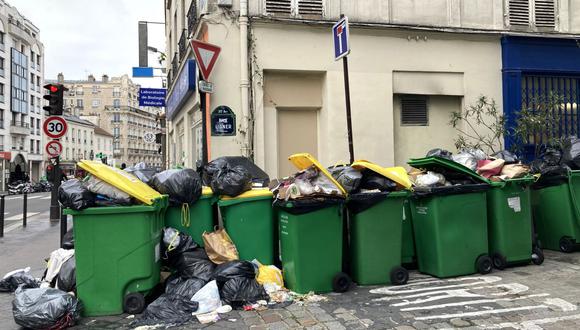 Esta fotografía tomada el 9 de marzo de 2023 muestra contenedores de basura domésticos en una calle de París que se han ido acumulando desde que los recolectores de basura se declararon en huelga contra la reforma de pensiones propuesta por el gobierno francés el 6 de marzo de 2023. (Foto de Christophe DELATTRE / AFP)