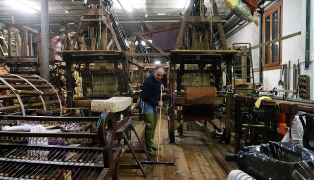 Un hombre limpia el piso después de haberse inundado su taller en Venecia.  (Foto: Reuters)