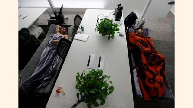 Han Liqun (a la izq.), gerente de Recursos Humanos de RenRen Credit Management Co., y el ingeniero de Tecnologías de la Información Xiang siyang duermen en camas plegables en su oficina después de terminar el trabajo del día en Pekín, China. (Foto: Reuter