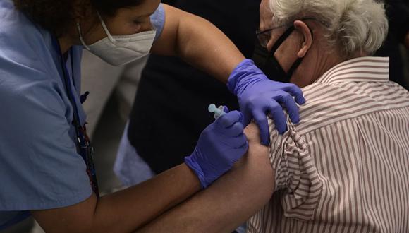 Un trabajador sanitario vacuna a un hombre contra el coronavirus durante una campaña de vacunación masiva para personas mayores de 60 años en el WiZink Center - Palacio de Deportes arena de Madrid (España), el 9 de abril de 2021. (JAVIER SORIANO / AFP).