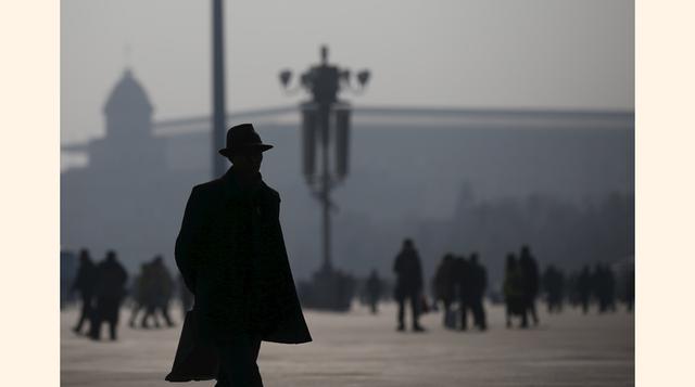 Solo siluetas se aprecian en la Plaza Tiananmen, en Beijing, debido a la alta contaminación. (Foto: Reuters)