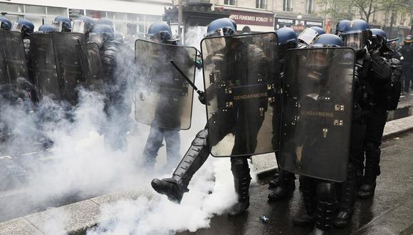 Un policía antidisturbios lanza un bote de gas lacrimógeno durante los enfrentamientos en la marcha anual del Primero de Mayo en París, Francia, el 1 de mayo de 2023. (Foto: EFE)