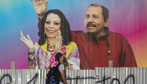 Un hombre camina por una clínica de salud móvil que muestra una foto del presidente de Nicaragua, Daniel Ortega (derecha) y su esposa, la vicepresidenta Rosario Murillo (derecha) en Managua. (Foto: INTI OCON / AFP)