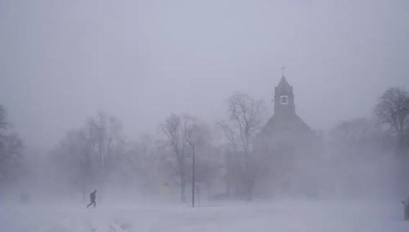 Un peatón solitario con raquetas de nieve cruza Colonial Circle cerca de la Iglesia Episcopal St. John's Grace en Buffalo, Nueva York, el sábado 24 de diciembre de 2022. (Derek Gee/The Buffalo News vía AP).