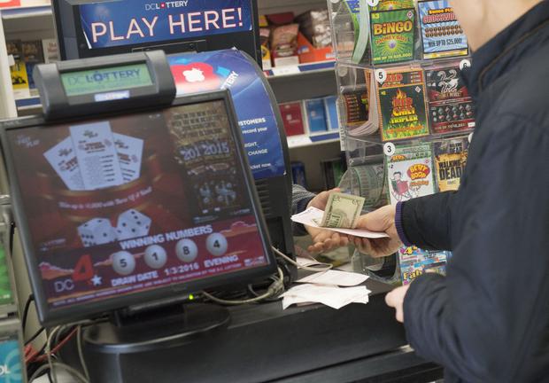 Un hombre compra un billete de lotería Powerball en una licorería en Washington, DC, 4 de enero de 2016 (Foto: Saul Loeb / AFP)