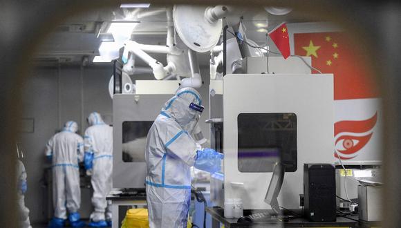 Laboratory technicians wearing personal protective equipment (PPE) work on samples to be tested for the Covid-19 coronavirus at the Fire Eye laboratory, a Covid-19 testing facility, in Wuhan in China's central Hubei province early on August 5, 2021. (Photo by AFP) / China OUT