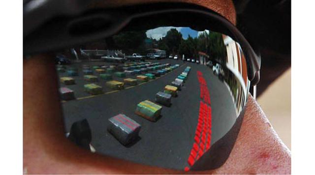 Cúcuta, Colombia. Homicidios: 183. Población: 643.666. Tasa de homicidios: 28.43. En la imagen, paquetes con siete toneladas de marihuana se reflejan en los lentes de un policía colombiana en Cúcuta. (Foto: Getty)