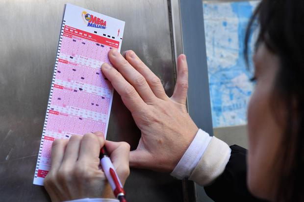 A woman fills a Mega Millions lottery ticket in hopes of becoming a millionaire in New York City on October 19, 2018 (Photo: Angela Weiss/AFP)