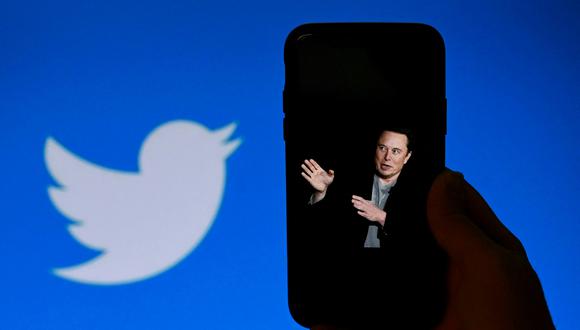 (ARCHIVOS) En esta foto ilustrativa de archivo tomada el 4 de octubre de 2022, la pantalla de un teléfono muestra una foto de Elon Musk con el logo de Twitter de fondo en Washington, DC. (Foto de OLIVIER DOULIERY / AFP)