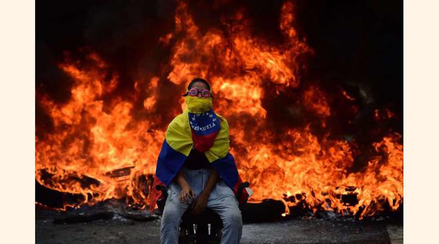 Un activista de la oposición venezolana sentado frente a una barricada en llamas durante una manifestación contra el presidente Nicolás Maduro el 24 de abril de 2017 en Caracas.(foto: Ronaldo Schemidt).