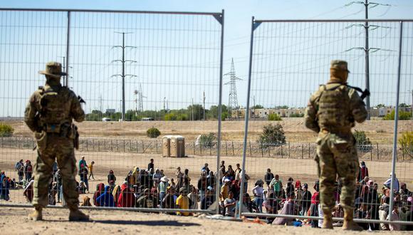 Migrantes esperan junto a una valla fronteriza bajo la vigilancia de la Guardia Nacional de Texas, Estados Unidos, el 10 de mayo de 2023. (AP Foto/Andrés Leighton).