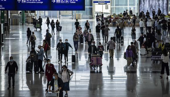 Los pasajeros caminan por el Aeropuerto Internacional de Hong Kong en Hong Kong el 8 de diciembre de 2022. (Foto de ISAAC LAWRENCE / AFP)