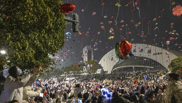 Personas lanzan globos durante una celebración de Año Nuevo en Wuhan, en la provincia central china de Hubei, el 1 de enero de 2023. (Foto de AFP)