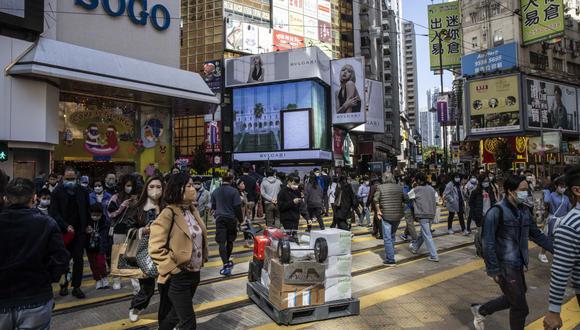 La gente camina por un distrito comercial en Hong Kong el 22 de diciembre de 2022. (Foto de ISAAC LAWRENCE / AFP)