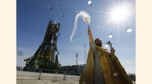 Un sacerdote ortodoxo celebra una ceremonia de bendición delante de la nave espacial Soyuz TMA-14M, situada en la plataforma de lanzamiento en el Cosmódromo de Baikonur. (Foto: Reuters)